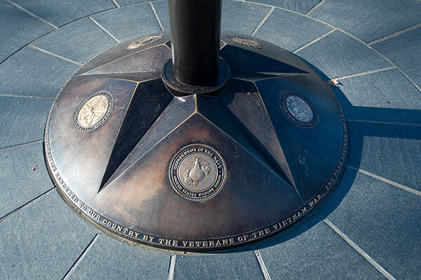 Flagpole base showing insignia of he Army, Marine Corps, Navy, Air Force, and Coast Guard