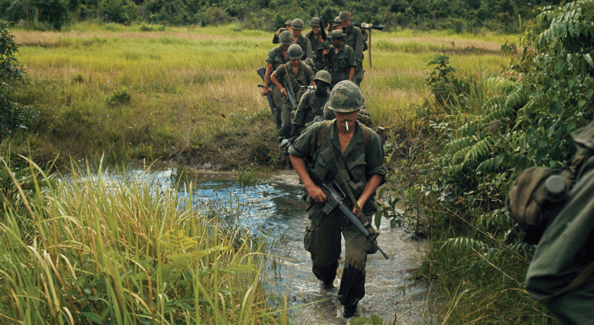 Troops march through a marsh in Vietnam