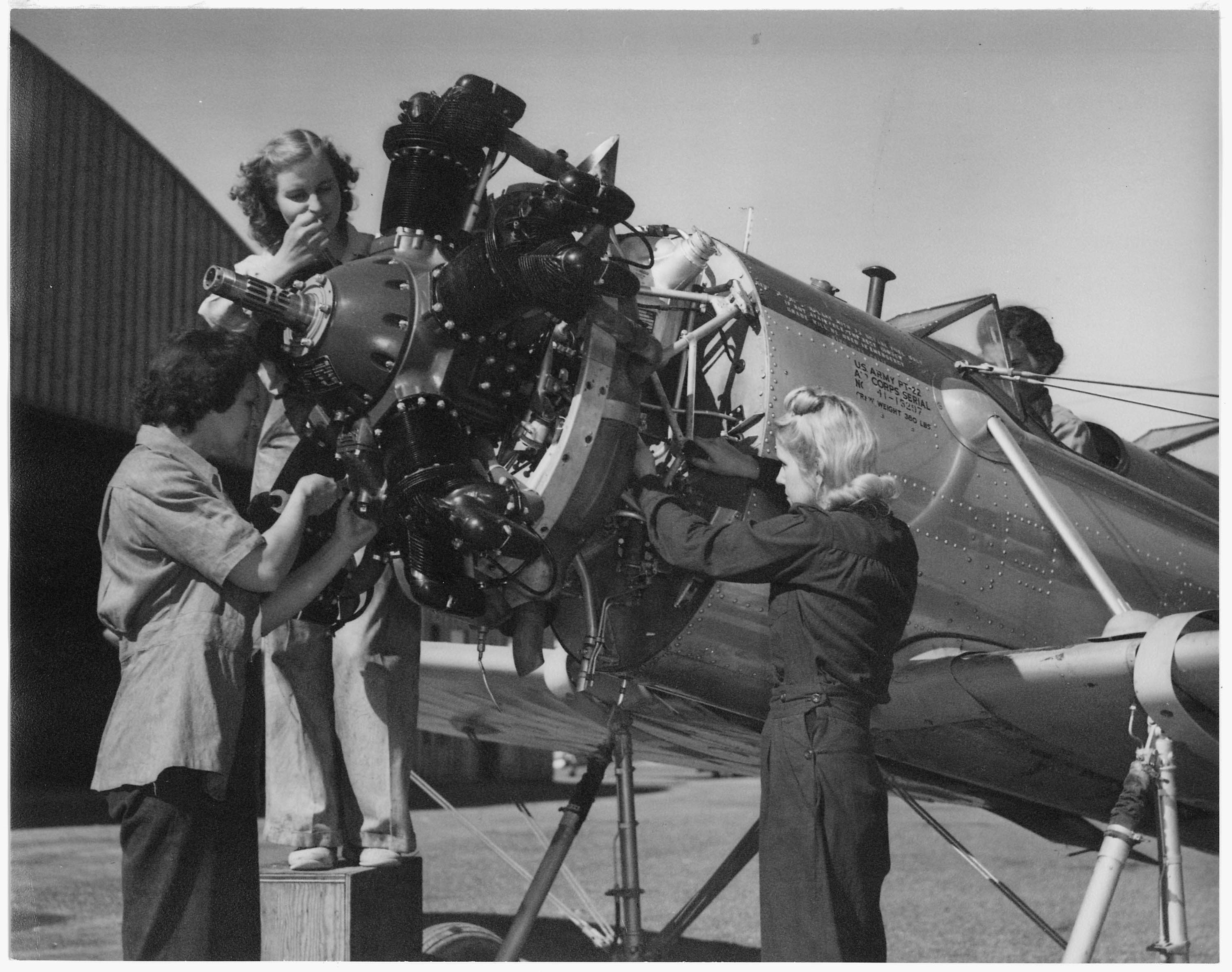 a photo of three women working on a plane during World War I