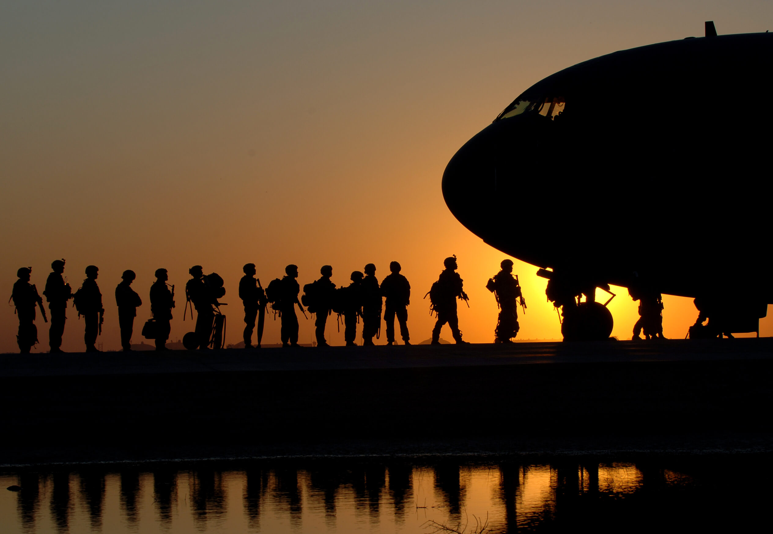 Soldiers board a military plane that will take them into Iraq