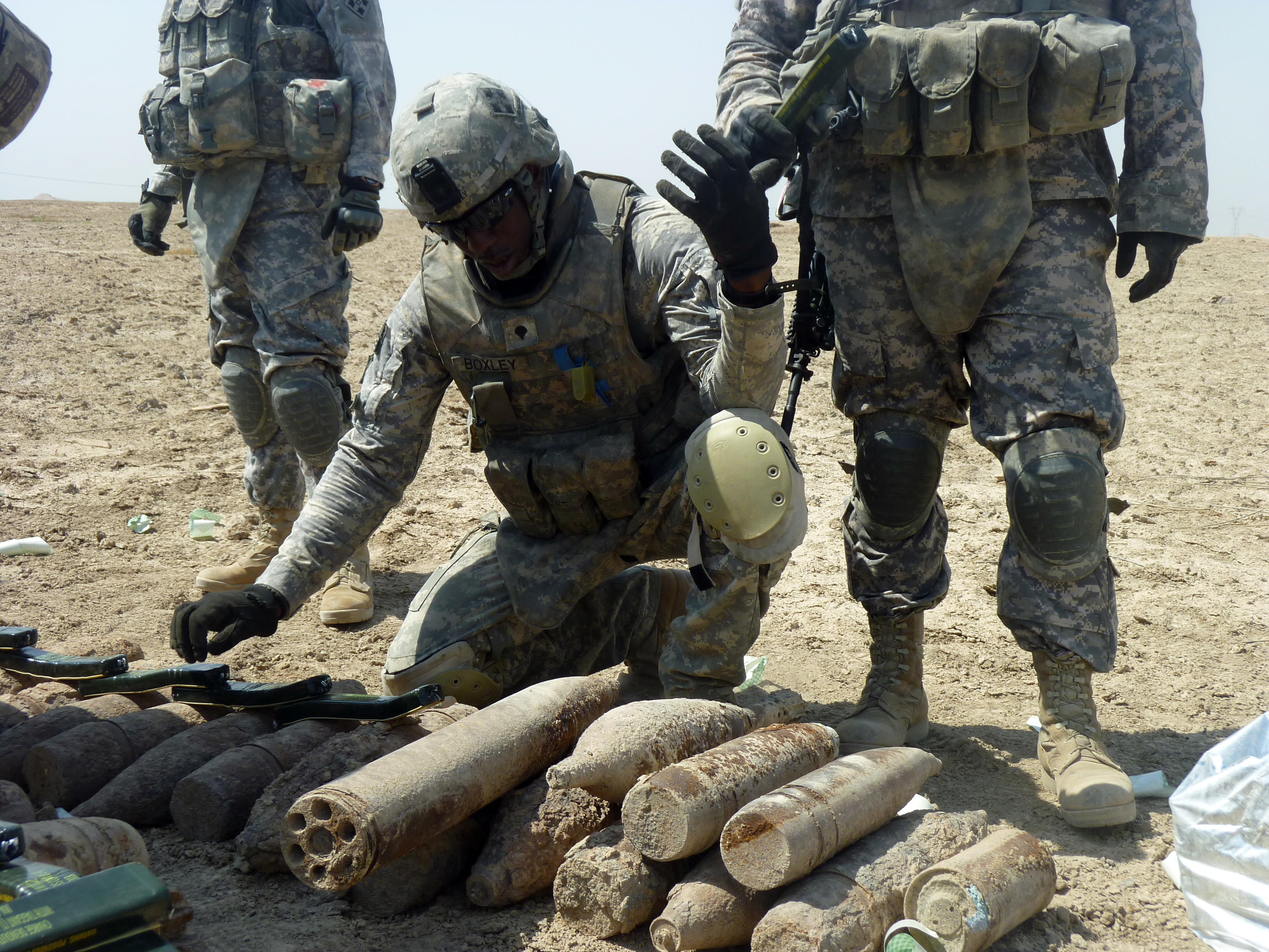 A soldier inspecting and defusing bombs in Baghdad