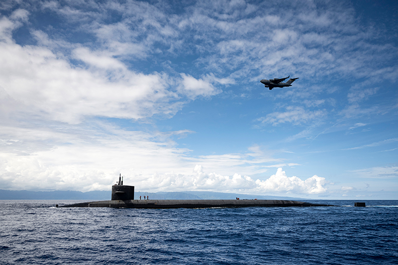 A C-17 Globemaster III flying in to drop payload to USS Henry M. Jackson.