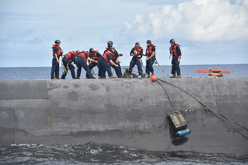 The crew of the Ohio-class ballistic-missile submarine USS Henry M. Jackson (SSBN 730) retrieve an airdropped payload from an Air Force C-17 Globemaster III.