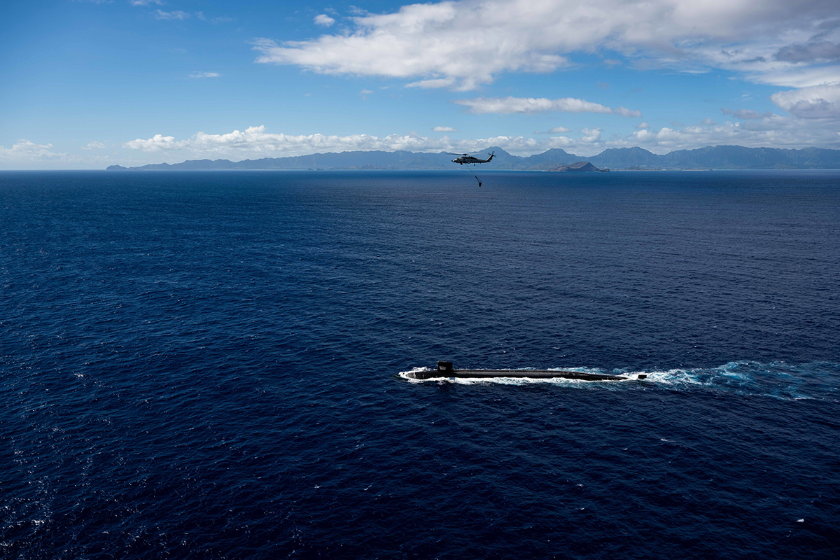 An MH-60R Sea Hawk prepares to deliver a payload to the Ohio-class ballistic-missile submarine USS Henry M. Jackson.