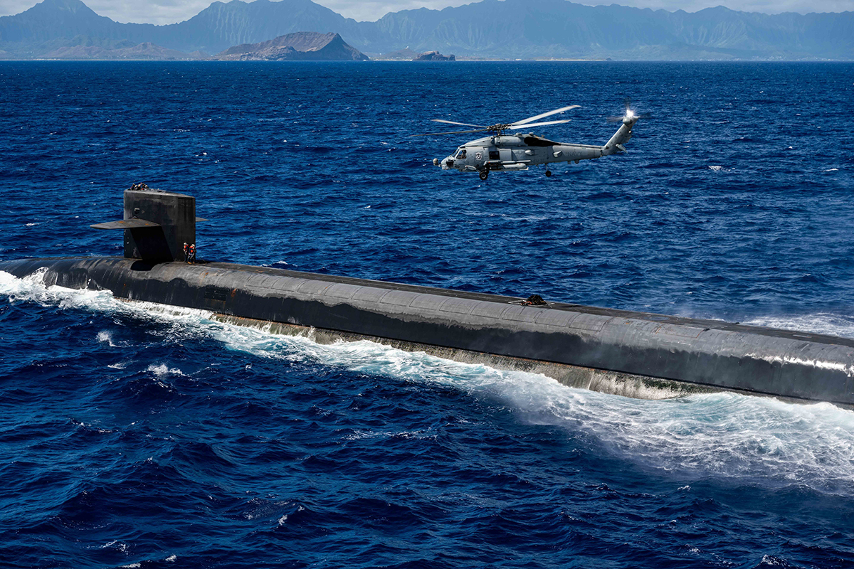 An MH-60R Sea Hawk hovering over the Ohio-class ballistic-missile submarine USS Henry M. Jackson.