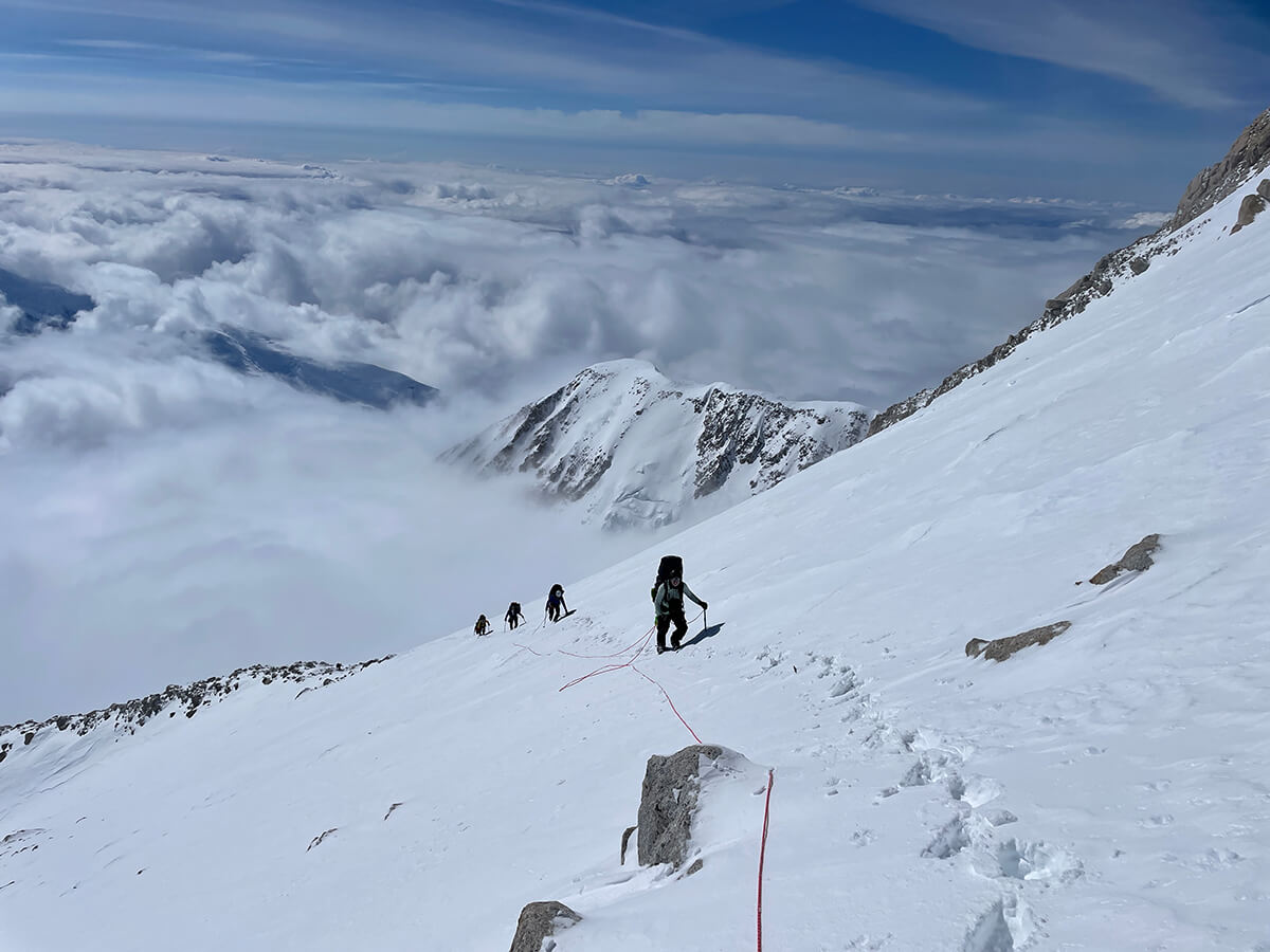 man climbing snow covered mountain