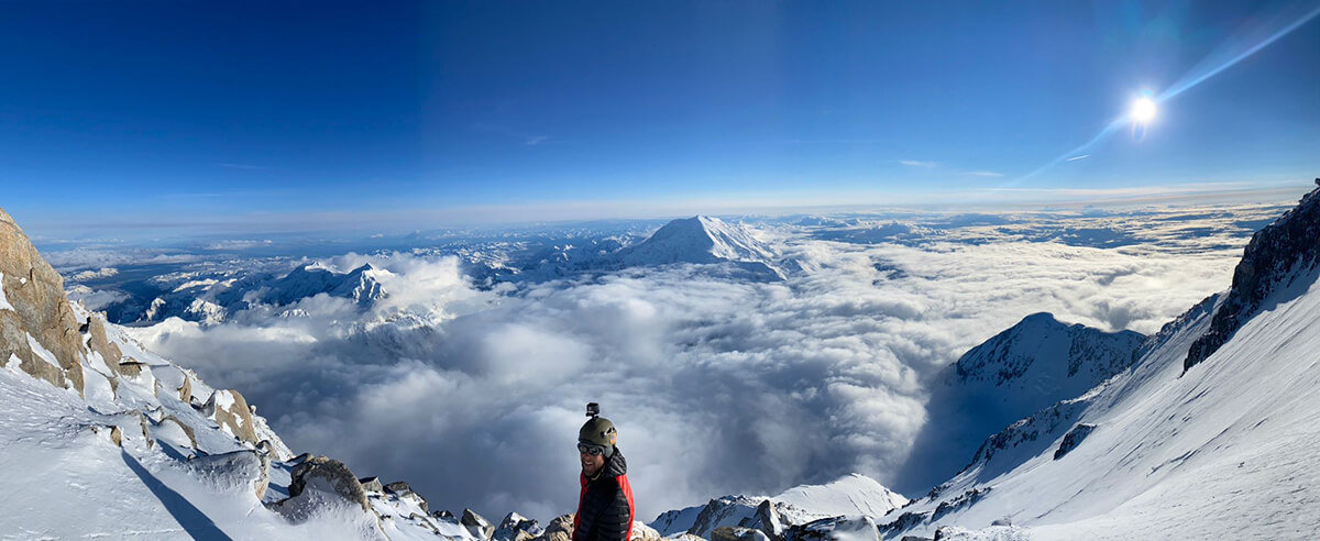 panoramic view of team member on mountain top