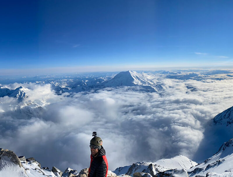 panoramic view of team member on mountain top thumbnail