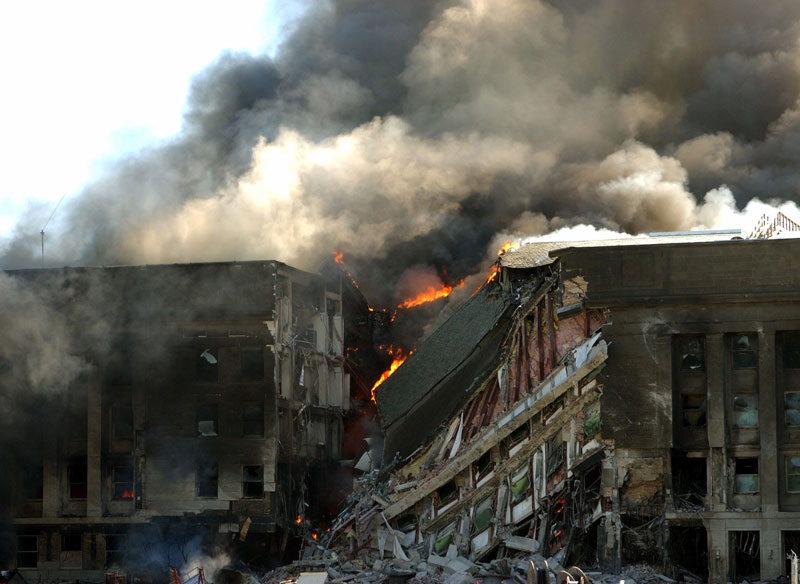 Smoke and flames rise from a damaged portion of the Pentagon.