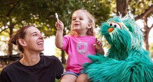 Smiling woman and child with muppet