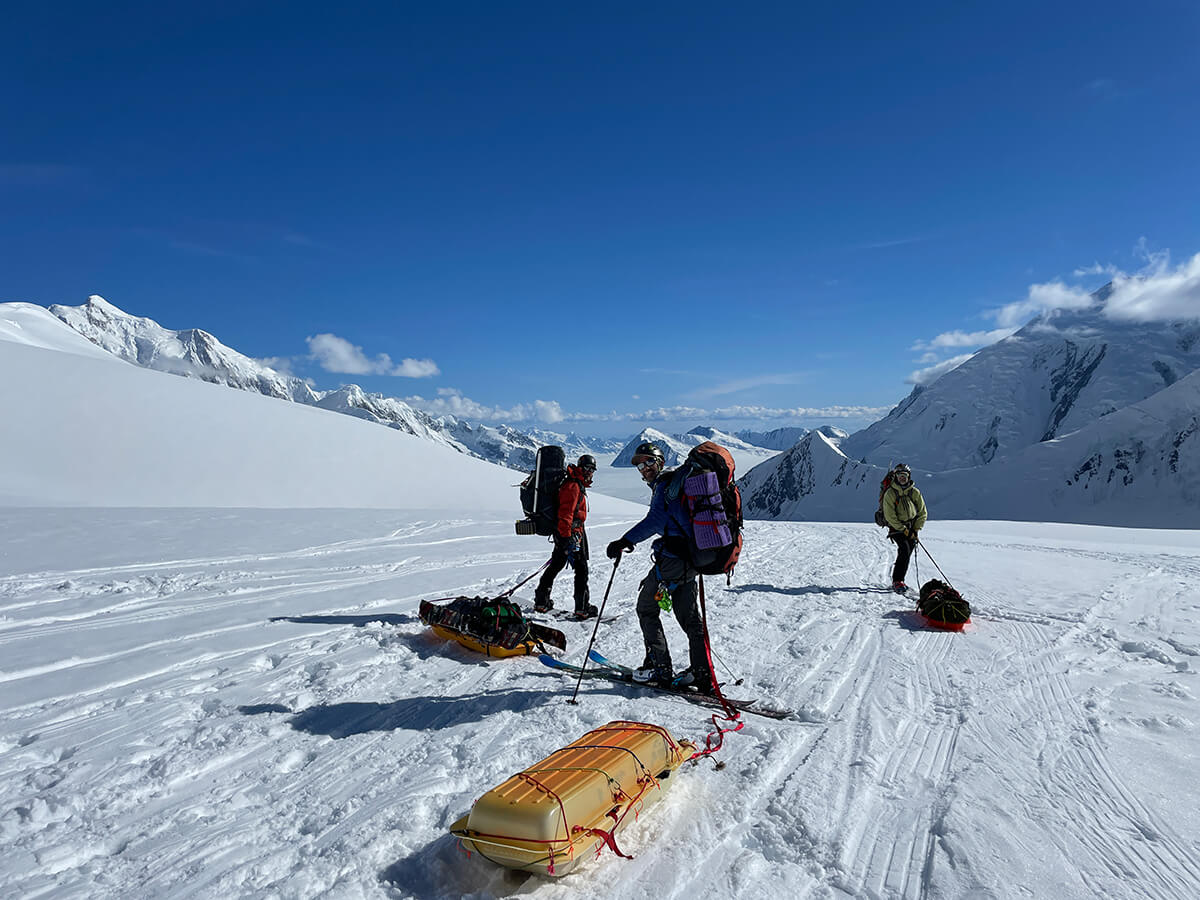 team members pulling sleds with equipment